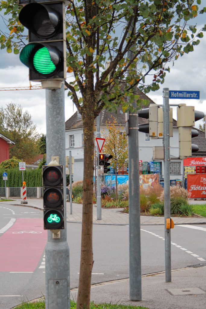 Die Fußgänger haben bereits Rot, Radler noch Grün; manche Autofahrer achten nicht richtig darauf.