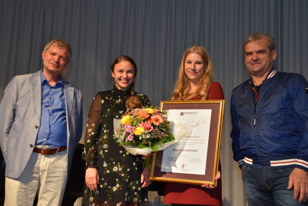 Melina Kühbandner, Zweite von links, neben ihrer Lehrerin Christine Sedlmeier wird vom Vorsitzenden Peter Rutz (rechts) und Schulleiter Gottfried Hartl (links) der Leonhard-Grötsch-Musikpreis verliehen.