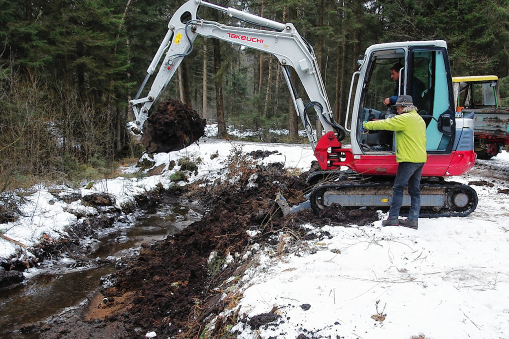 Auf dem gefrorenen Boden war der Einsatz eines Baggers kein Problem. Bio-Landwirt Georg Kurfer (stehend) ließ einen verlandeten Kanal im Hintermoos ausbaggern. Viele Tiere werden dort eine artgerechte Heimat finden.